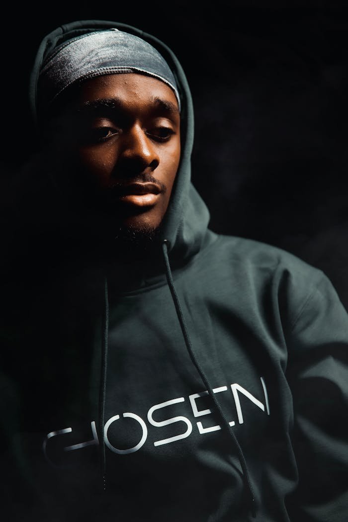 Crafting Captivating Headlines: Your awesome post title goes here Studio portrait of a man wearing a hoodie with CHOSEN text, set against a dark background.